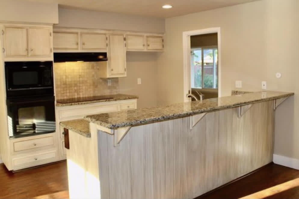 Outdated kitchen with light wood cabinets and dark granite countertops