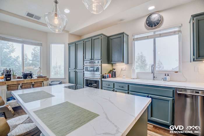 Modern kitchen in El Dorado Hills featuring quartz island, green cabinetry, pendant lighting, and large windows