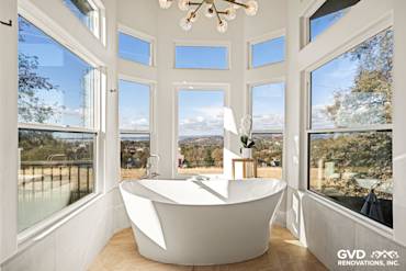 Freestanding BainUltra Thermomasseur tub beside large windows in a beautifully remodeled El Dorado Hills bathroom