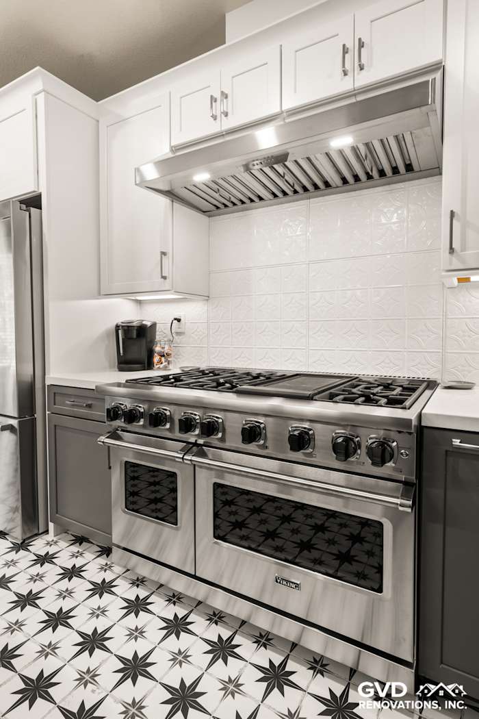 Modern kitchen remodel in Folsom featuring stainless steel stove, white cabinetry, and patterned black-and-white tile floor
