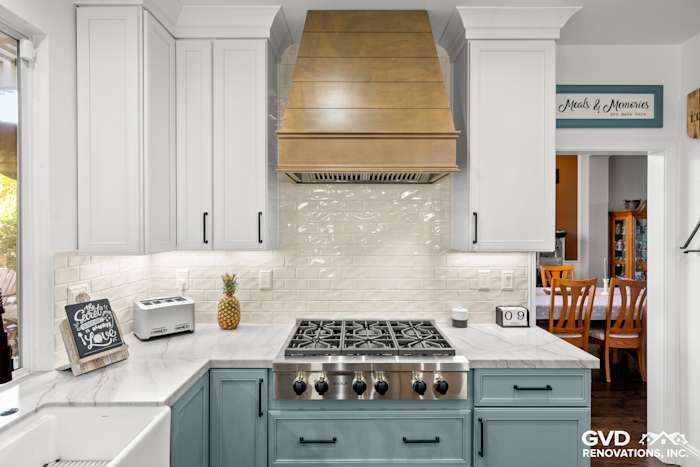 Elegant kitchen remodel with Fieldstone cabinetry, Denali White Quartzite countertops, and a custom range hood