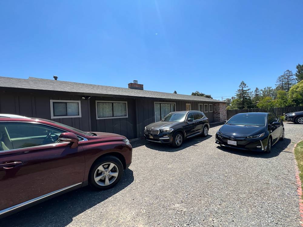 Gravel driveway with multiple cars outside a single-story home in Sacramento