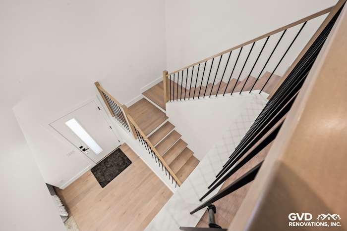 Modern staircase remodel with wooden steps and black railing in an Antelope home, featuring fresh flooring and a stylish