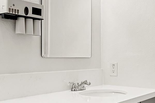 Modern bathroom with double sink vanity, custom cabinetry, and bright lighting fixtures in Sacramento remodel