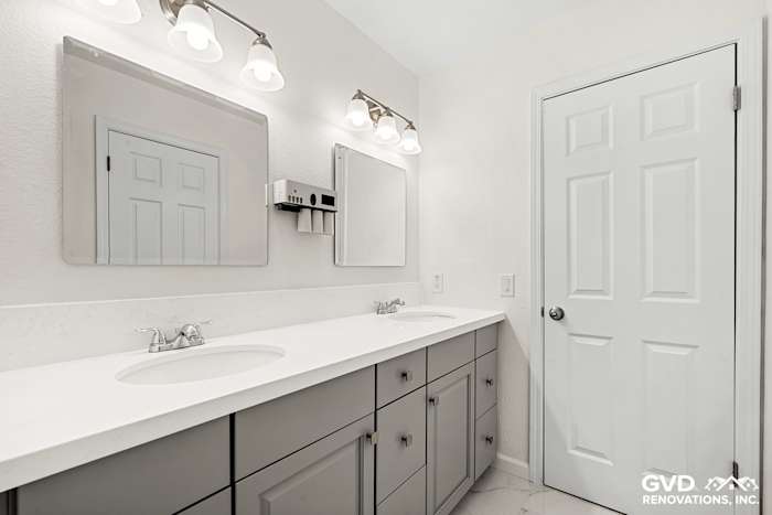 Modern bathroom with double sink vanity, custom cabinetry, and bright lighting fixtures in Sacramento remodel