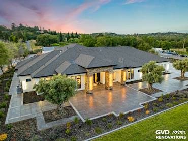 Stylish home exterior featuring premium roofing and stone accents, showcased in a serene landscape setting