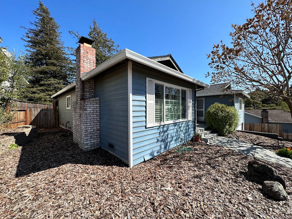 Established garden with gravel, shrubs, and a blue exterior in Sacramento's sunny neighborhood