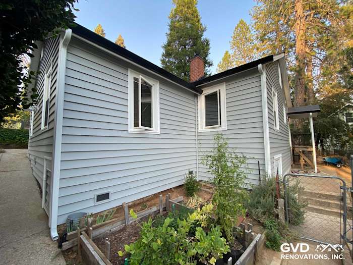 Light blue Prodigy Vinyl Siding on a home exterior, featuring white windows and surrounding greenery in Grass Valley, CA