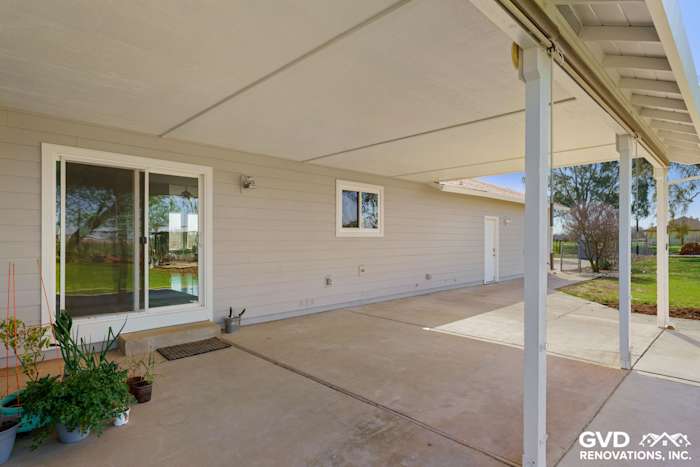 Pearl Gray James Hardie siding with Arctic White trim on a Galt home exterior, featuring Anlin windows and covered patio