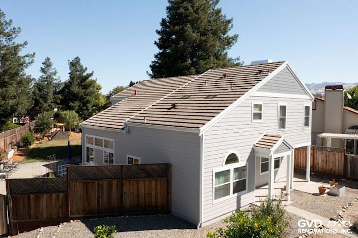 Light gray James Hardie siding and Arctic White trim on a Petaluma home with new vinyl windows and landscaped yard