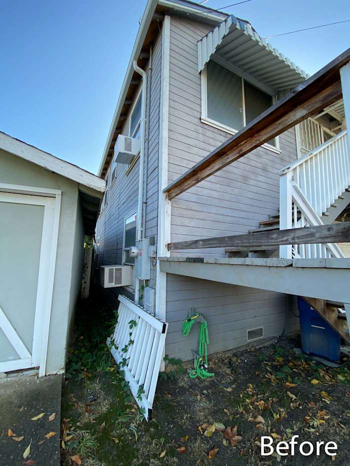 Side view of a home in Rio Vista with old siding, damaged steps, and a cluttered area before renovations