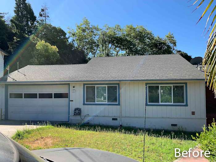 Before image of a home featuring a traditional design, with existing siding and older-style windows in need of renovation