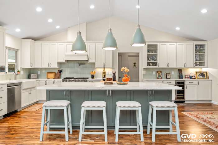 Stylish kitchen remodel featuring custom island cabinets, light green pendant lights, and a white quartz countertop