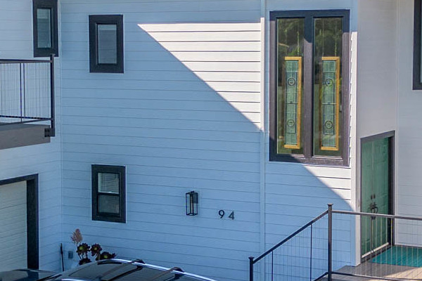 Modern home exterior featuring James Hardie Arctic White siding, Anlin Catalina windows, and a new deck in San Rafael, CA