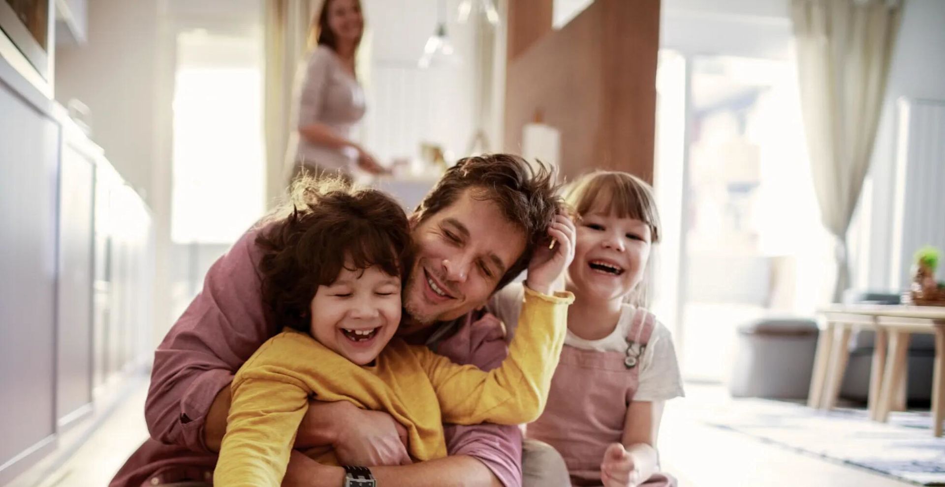 pai e filhos abraçados e a brincar juntos