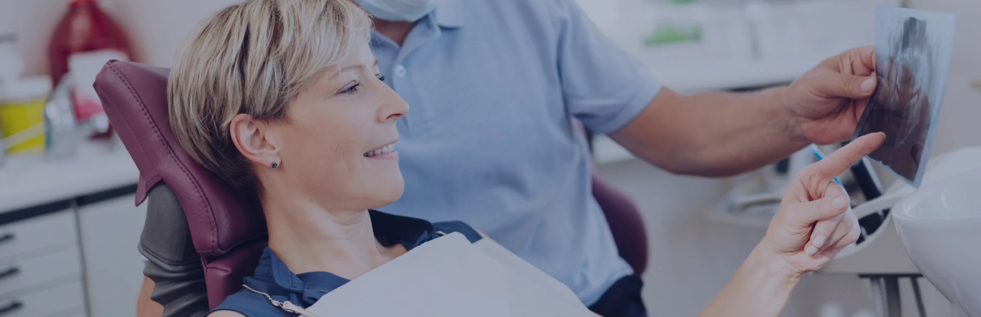 A dentist explains an image of a dental imprint to his patient, while she is smiling and confident because she knew what to expect at the dentist.