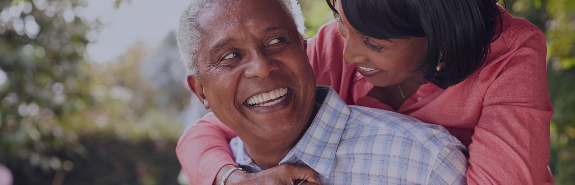 A couple in their 50s are smiling confidently thanks to Fixodent discussing "What are Immediate Dentures?"