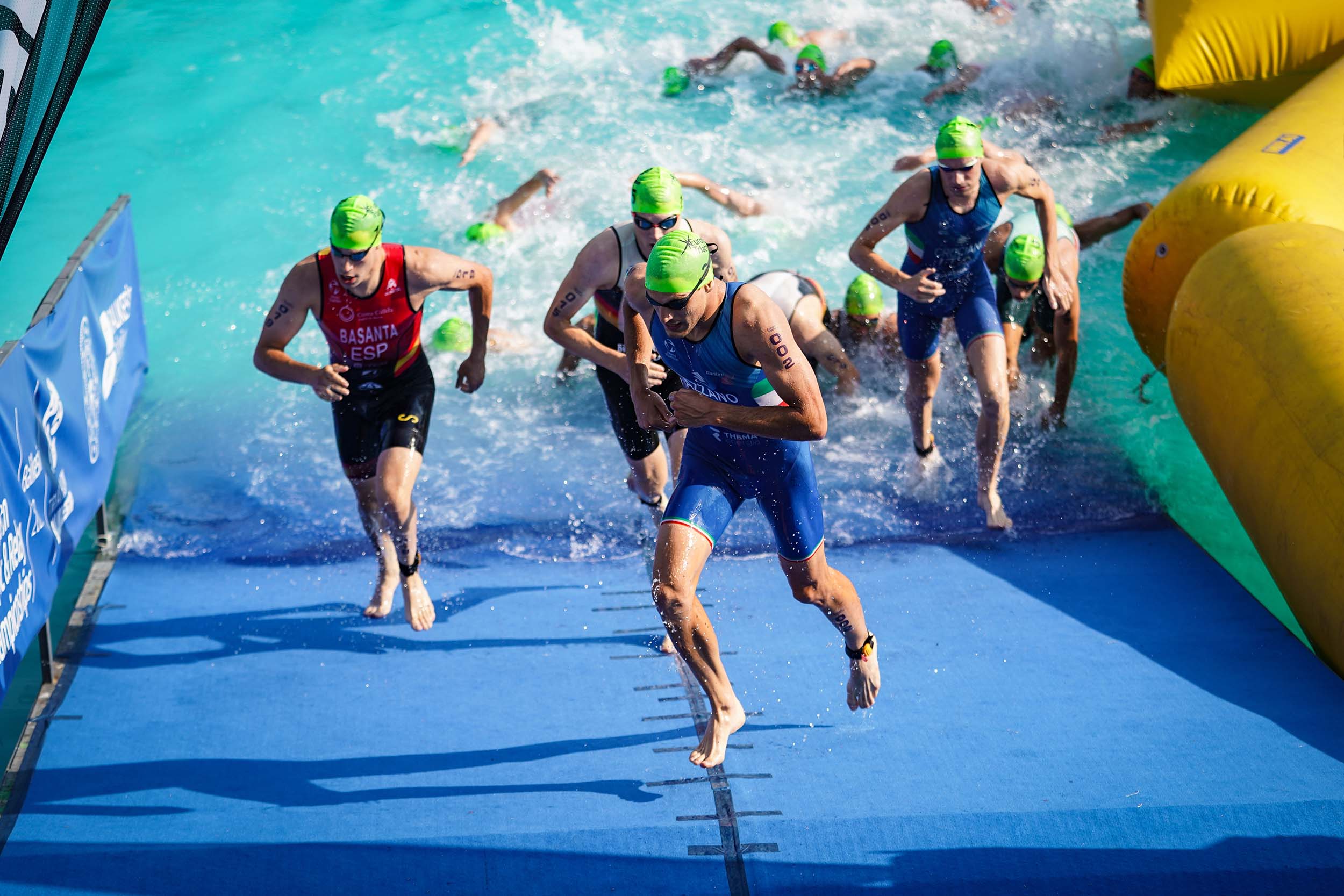 Triathletes exiting the water. Photography by: EvrenKalinbacak/Shutterstock