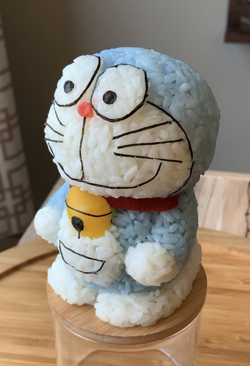 Doraemon, made of rice soaked in butterfly pea flowers, yellow and red bell peppers, and nori.