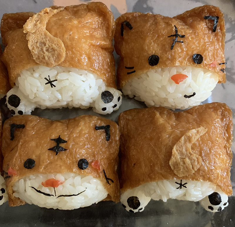 Front and back views of cats made of rice, tofu wrappers, tomato, and nori.
