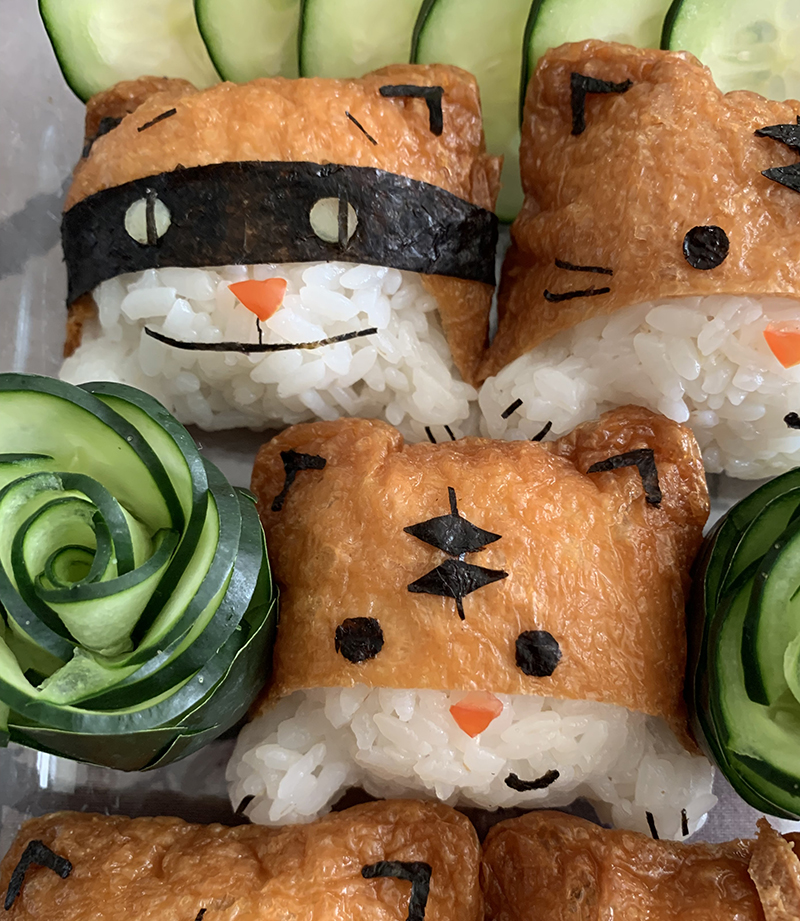 Cats made of rice, tofu wrappers, tomato, and nori.