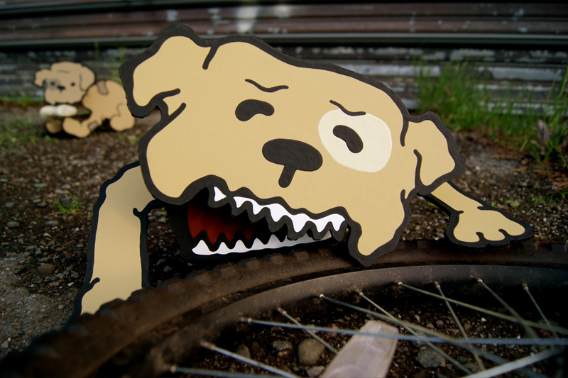 Cardboard dog taking a bite out of a bicycle tire