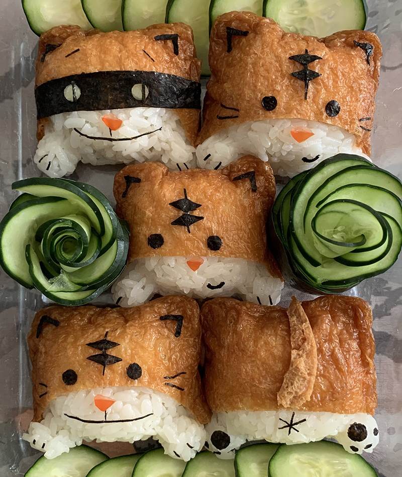 Front and back views of cats made of rice, tofu wrappers, tomato, and nori.