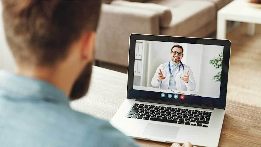 man talking to a doctor via video on his laptop