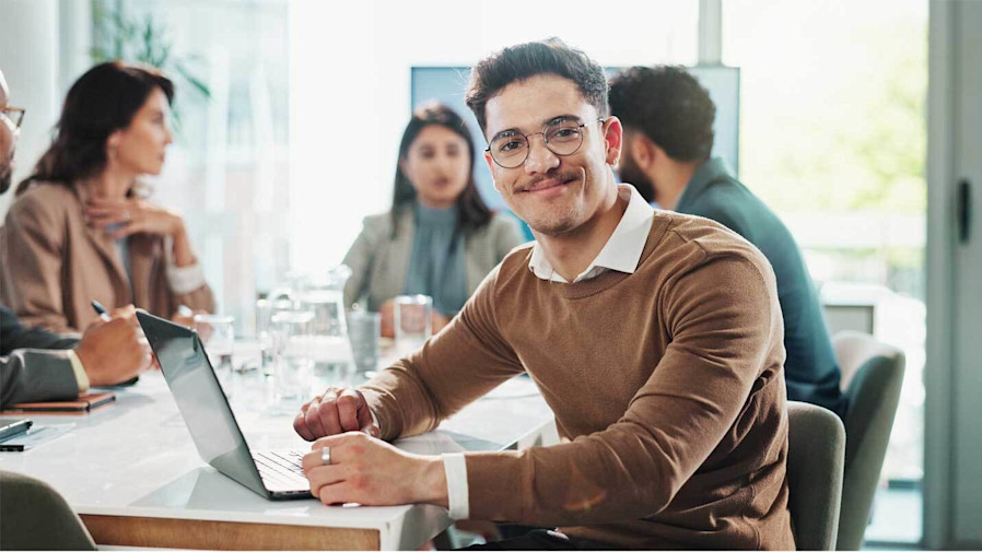 Man sitting at his desk and smiling at the camera