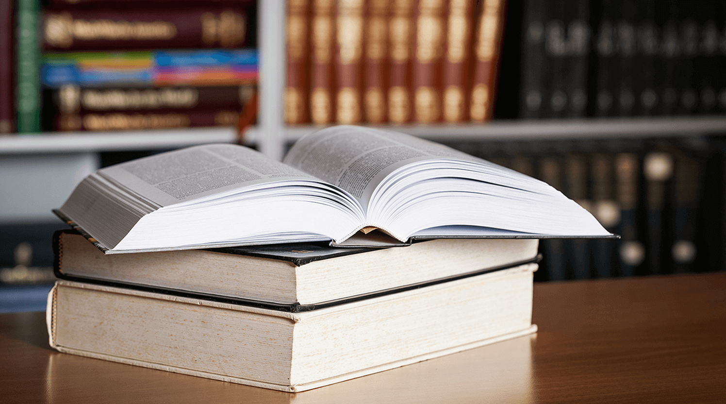 Open-book-stacked-on-two-other-books