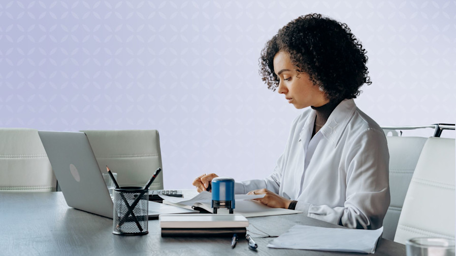 female doctors sitting at her desk and charting