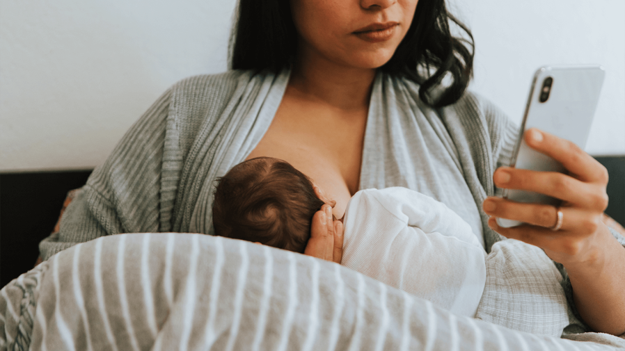 women breastfeeding her baby while on video call with lactation consultant