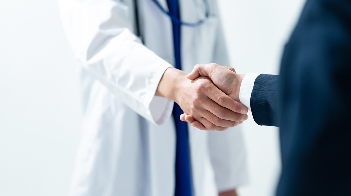 doctor and business man shaking hands in agreement