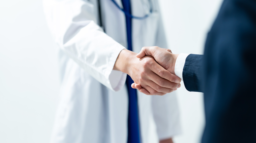 doctor and business man shaking hands in agreement