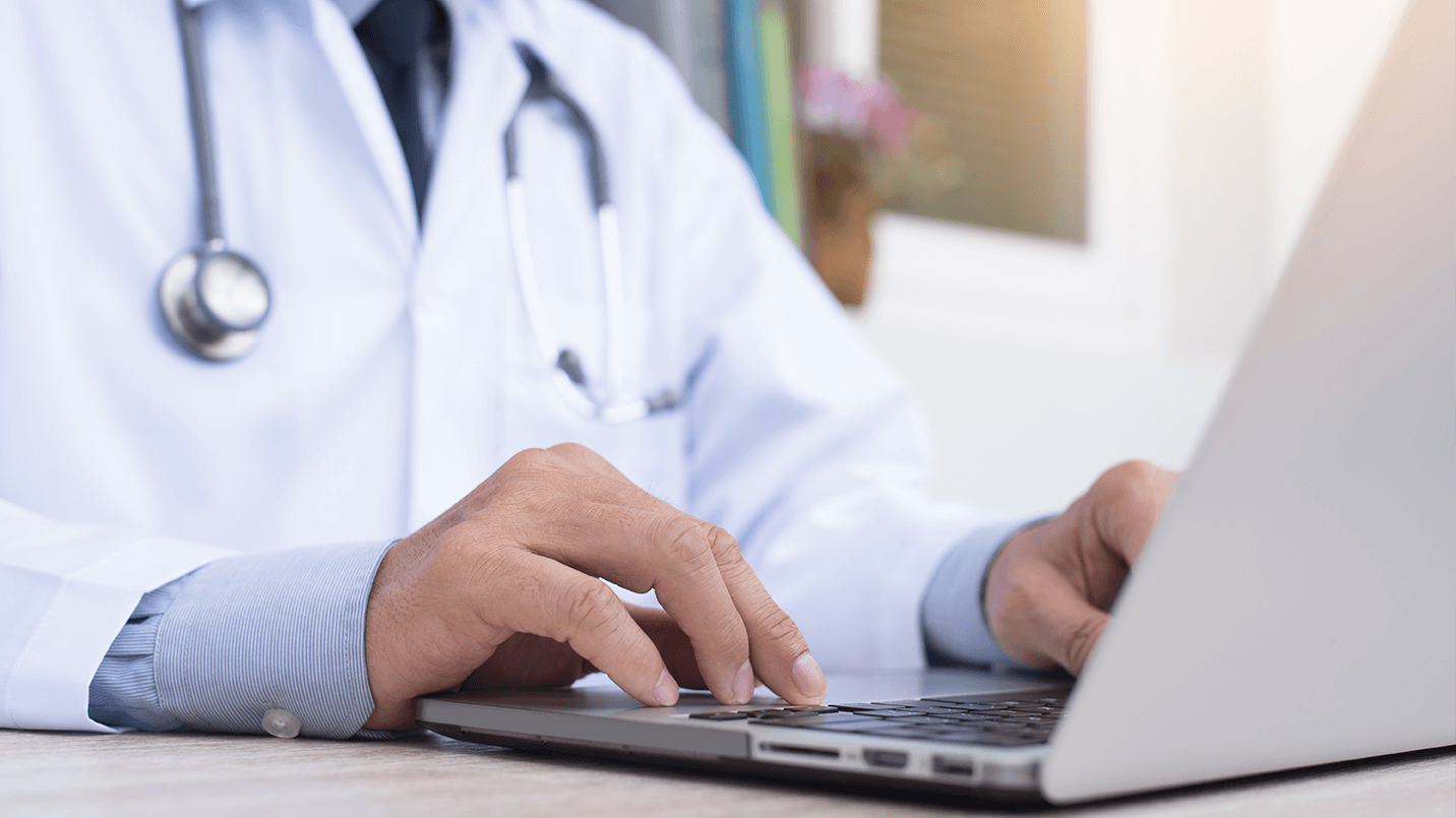 Close up of a clinician working on a laptop