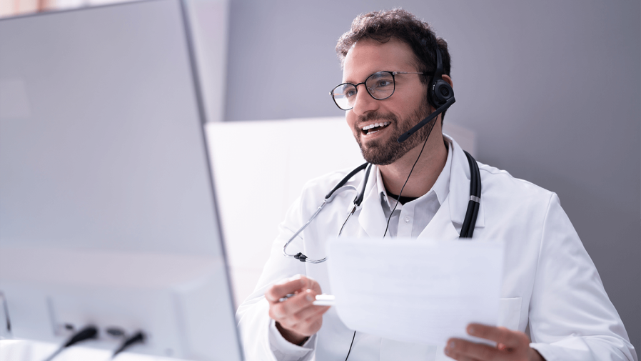 Male physician seamlessly using telemedicine to meet with his patient real-time with video conferencing