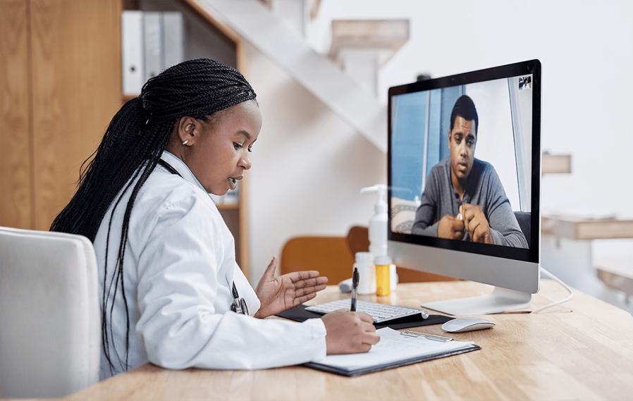 black female doctor on video call with black male patient