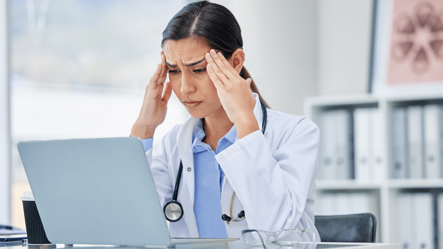 Female-healthcare-worker-frustratedly-looking-at-a-computer-screen