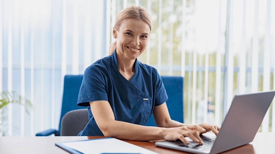 female provider smiling and charting notes after telehealth visit