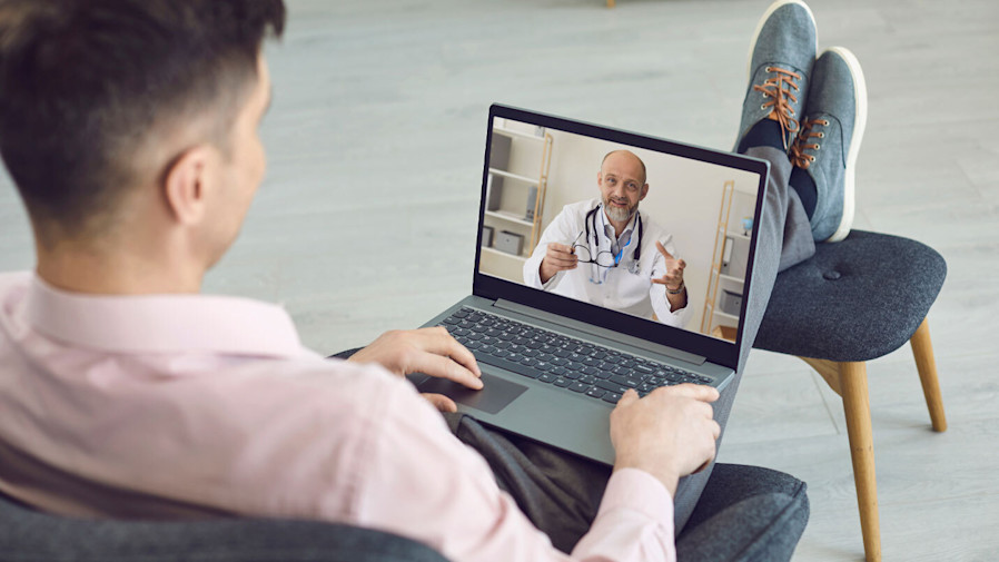 man sitting down and on a video call with his doctor