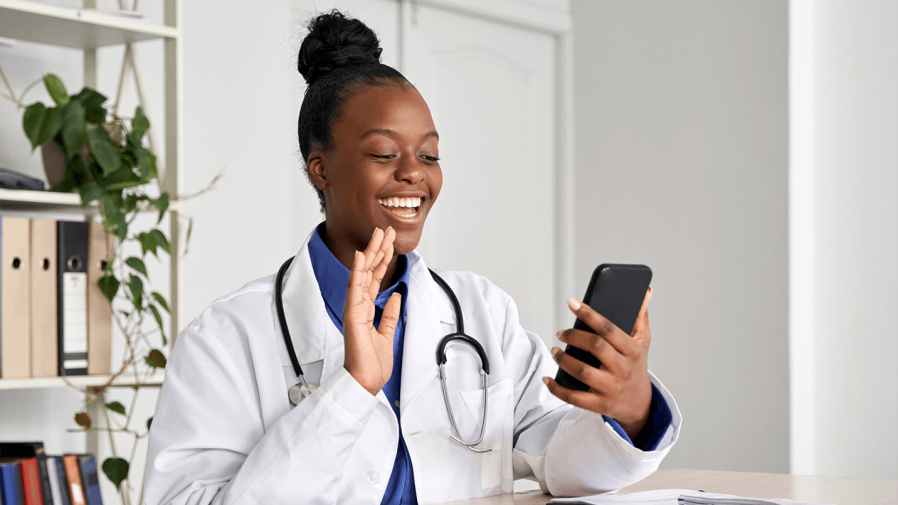 female African American physician talking to patient on video from her phone