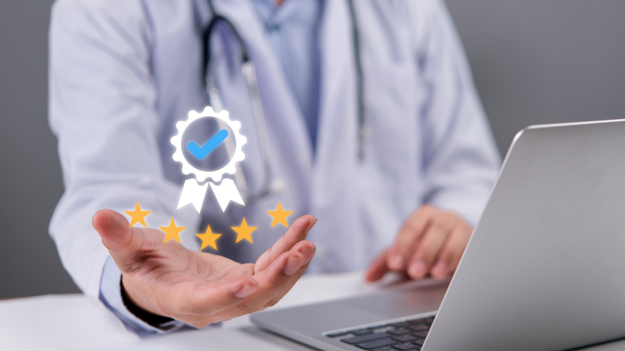 doctor in background sitting in front of laptop holding out hand with a certification ribbon graphic hovering above it