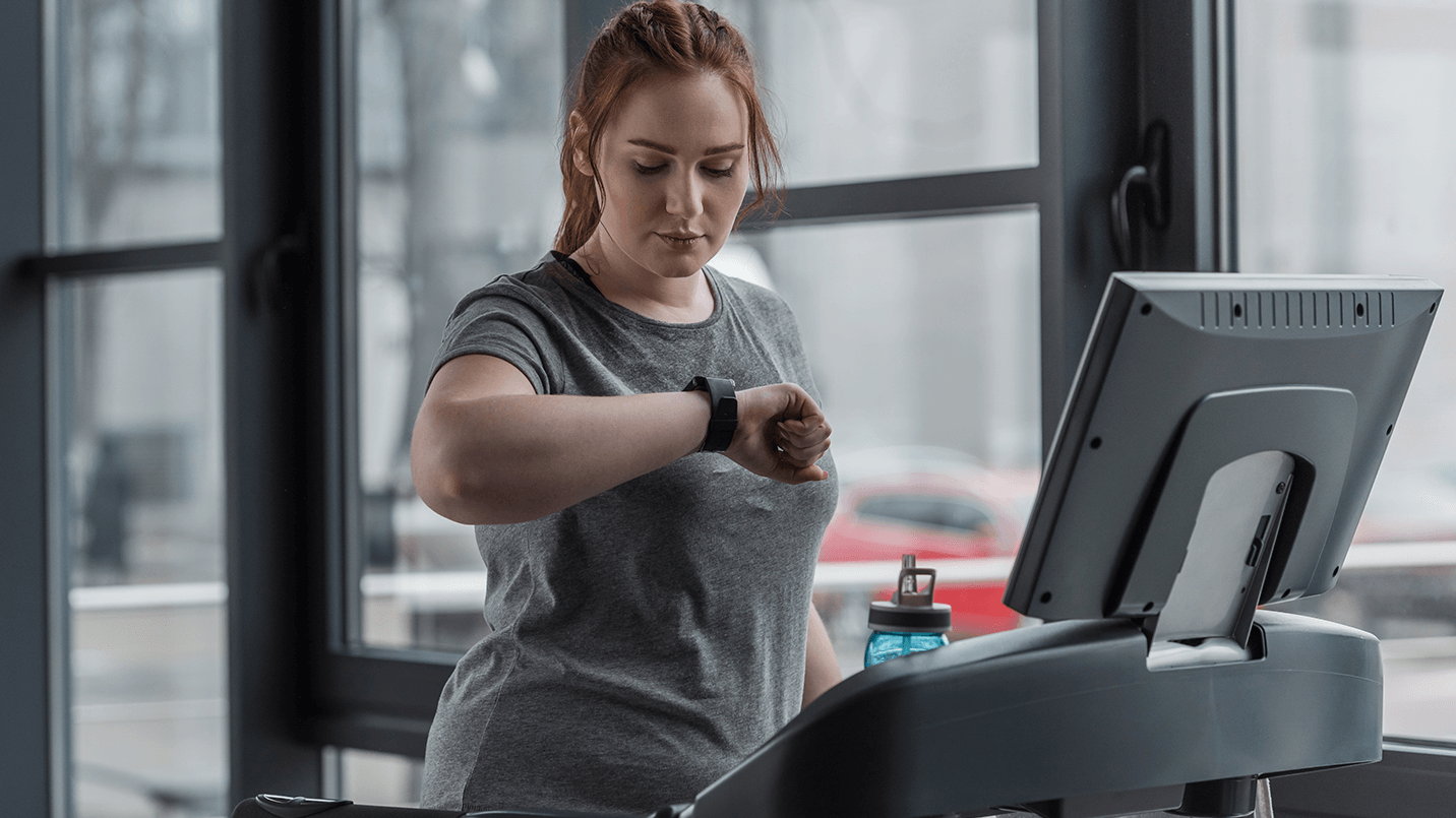 Patient running on a treadmill, checking her smart watch