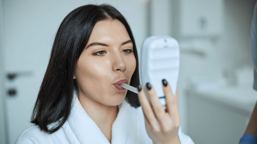 woman blowing into an electronic spirometer 