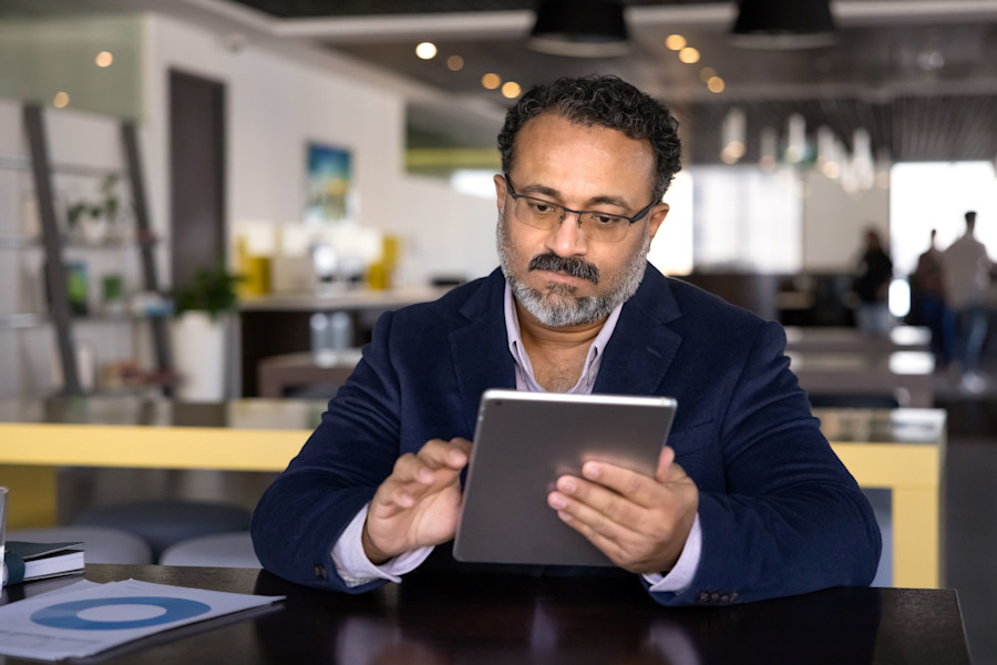 Professional worker in an office is looking at a digital tablet. 