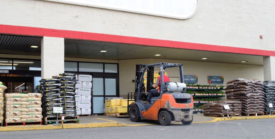 Worker driving forklift at warehouse