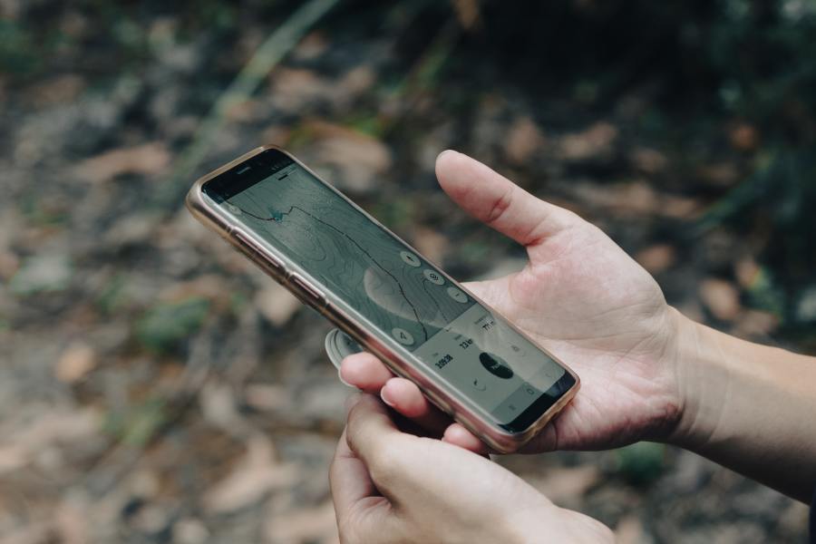 Close-up of an Android phone held in a person's hand, with the map function pictured onscreen.