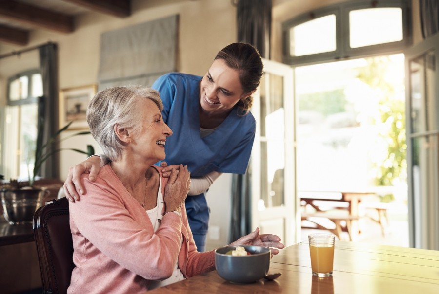 A retirement home setting with a female staff member talking to another resident