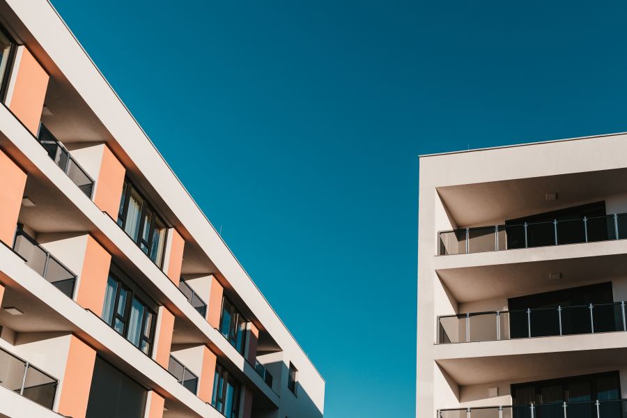 Residential apartment buildings against a blue sky background.