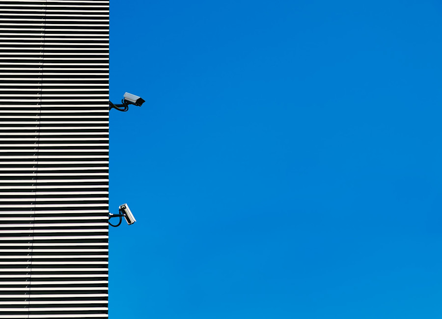 Security cameras on a building, signifying privacy and cyber safety.